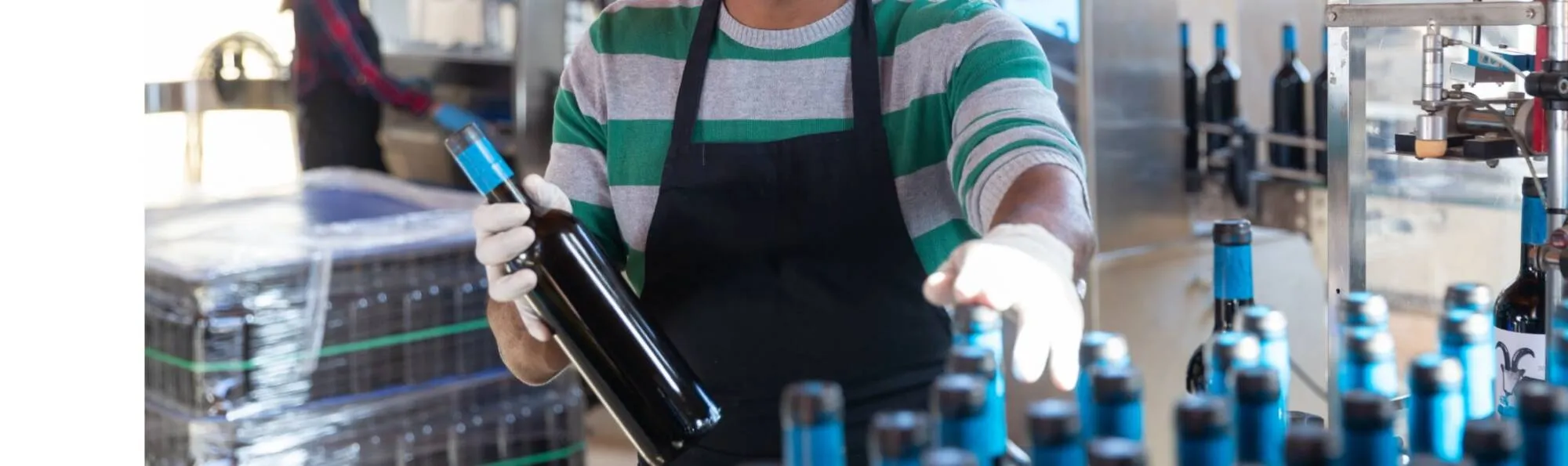 A Manutex operator holding a bottle of wine