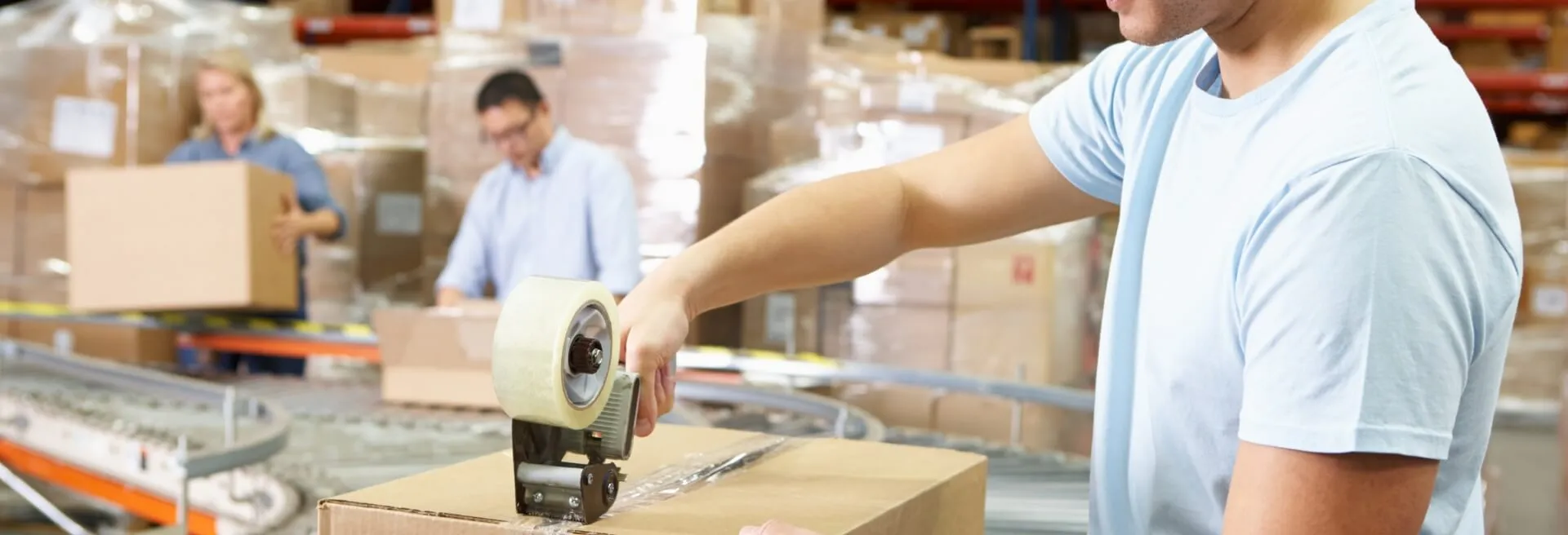 Operator taping up a box in a warehouse